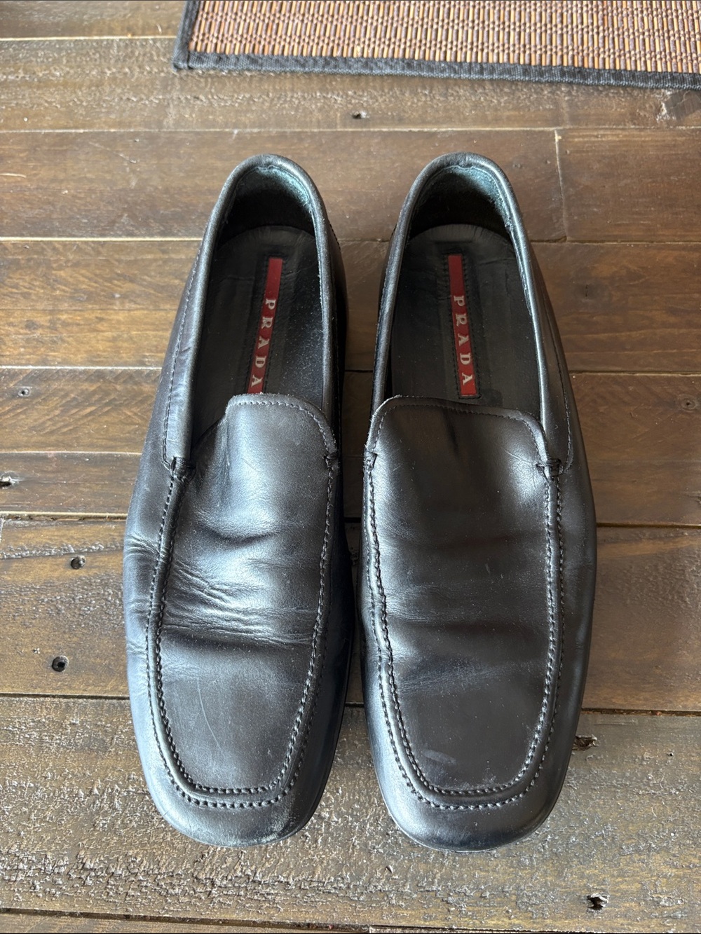 Prada Men's Black Leather Slip-On Loafers with Red Insole Detail